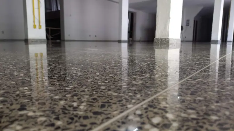 Granilite polido visto rente ao chão, com colunas ao fundo